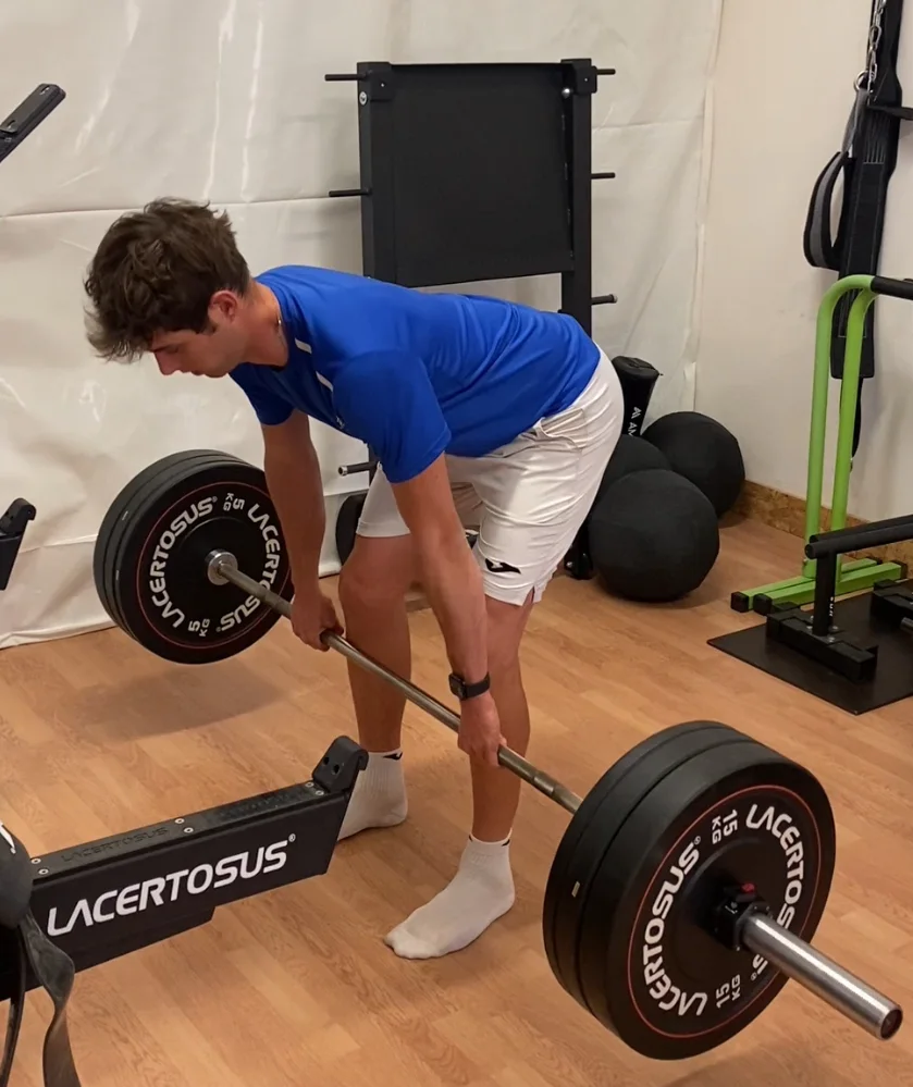 Leonardo lavora con il bilanciere in palestra