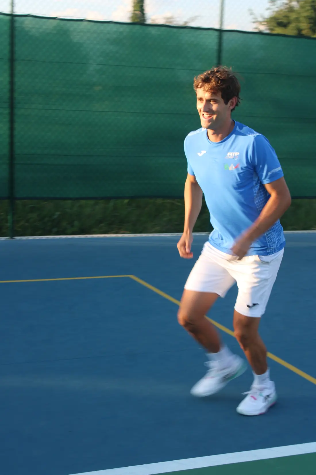 Leonardo sorride mentre si muove sul campo da tennis